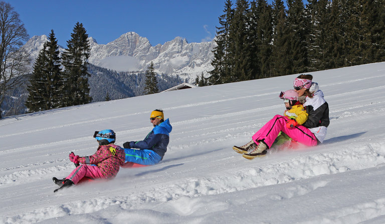 Familie beim Zipfelbobfahren.  | © Hans-Peter Steiner